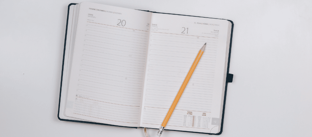 A diary is open, a pencil rests on a page